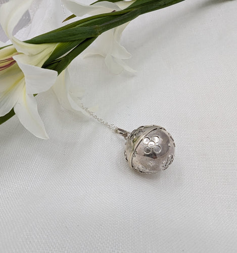 Silver sphere with silver flower detail on a silver chain