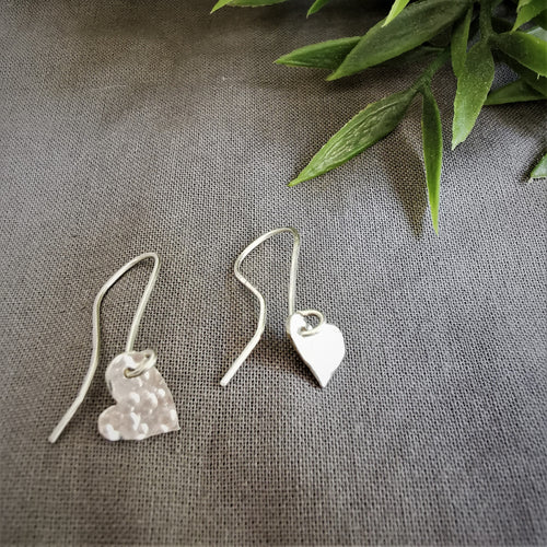 Small silver hearts with hammered texture set as drop earrings