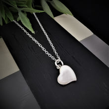 Load image into Gallery viewer, Mother of pearl heart pendant tilted at an angle on a silver chain
