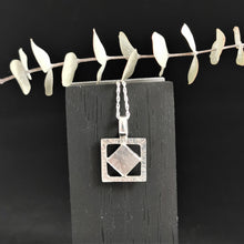 Load image into Gallery viewer, Diamond shaped meteorite slice dangling within a silver hammered texture square pendant hanging on a rope chain
