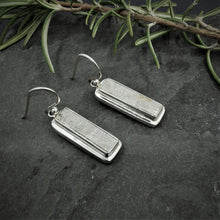 Load image into Gallery viewer, Long rectangular meteorite slices set in a double bezel silver setting as dangle and drop earrings
