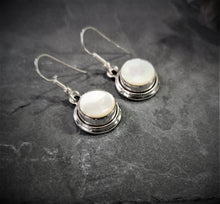 Load image into Gallery viewer, Mother of pearl round dangle and drop earrings set in silver double bezel
