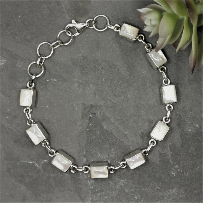 Nine rectangular white polished moonstones set in a silver chain bracelet