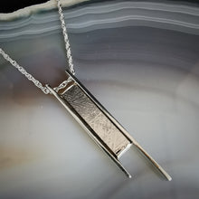 Load image into Gallery viewer, Long meteorite slice cased in long silver bar pendant on a rope chain
